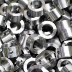 Shiny steel parts background. Regular industrial metal production pattern with selective focus.High precision steel automotive parts manufacturing by innovative CNC machining