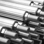 Shiny steel parts close-up background, long clean steel rods after fine cnc turning